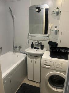 a bathroom with a sink and a washing machine at Limanowskiy village council in Łódź