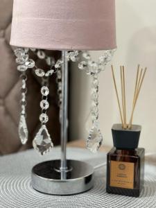 Una lámpara sobre una mesa junto a un frasco de perfume. en Palanga Old Town, en Palanga