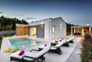 a house with a swimming pool and some chairs at Villa Dobranka in Barban