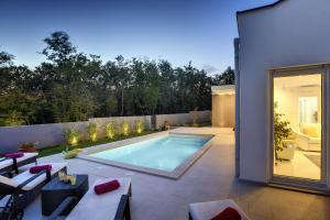a backyard with a swimming pool and a house at Villa Dobranka in Barban