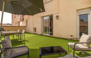 a patio with green grass and chairs and an umbrella at Stunning Apartment In Torremolinos in Torremolinos +12 photos
