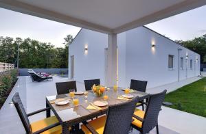 a dining table on a patio with chairs at Villa Dobranka in Barban