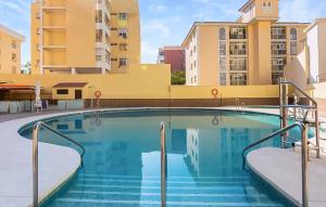 トレモリノスにあるGorgeous Apartment In Torremolinosの建物を背景にスイミングプール +16枚の写真