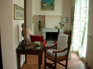 Appartamento Giardino Verde في مودينا: غرفة معيشة مع طاولة وكراسي ومدفأة