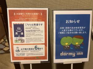 two signs in an asian language next to each other at Dormy Inn Express Koriyama in Koriyama