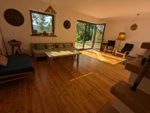 a living room with a couch and a table at Modernistyczna willa poety i aktorki, z widokiem na jezioro i góry oraz prywatnym basenem, sauną, kominkiem, lasem i ogrodem in Rożnów +91 photos