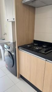 a kitchen with a stove and a washing machine at Top10,Lava-Seca,AR,Sacada,200m Shopping Aurora,Gleba Palhano in Londrina