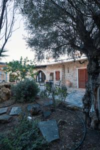 a house with a tree in front of it at Traditional Stone House - Where Tradition Meets Comfort in Mesa Chorio