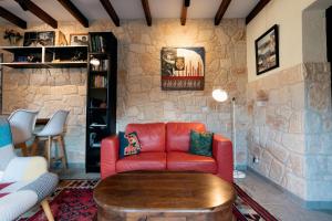 a living room with a red couch and a table at Traditional Stone House - Where Tradition Meets Comfort in Mesa Chorio