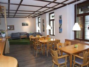 una sala da pranzo con tavoli e sedie in legno di Action Forest Hotel Titisee - nähe Badeparadies a Titisee-Neustadt
