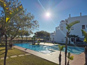a swimming pool with trees in front of a building at Penthouse Las Terrazas de la Torre in Roldán