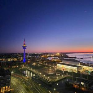 a view of a city with a tower at night at Ferienwohnung Moin in Bremerhaven
