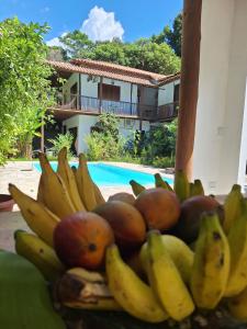 ポルト・セグロにあるRecanto da Mata Houseのプールの横に積まれたバナナやその他の果物