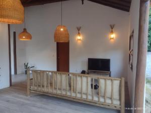 een woonkamer met een houten balustrade en een tv bij Casa Recanto da Mata - Trancoso in Porto Seguro