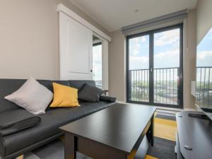 a living room with a black couch with yellow pillows at Amazing Views in Central Leeds - Pass The Keys in Leeds