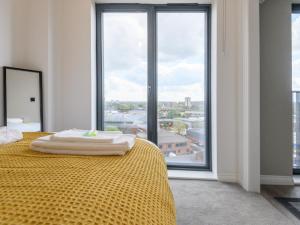 a bedroom with a yellow bed with a large window at Amazing Views in Central Leeds - Pass The Keys in Leeds