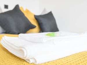 a stack of white towels on a bed with pillows at Amazing Views in Central Leeds - Pass The Keys in Leeds