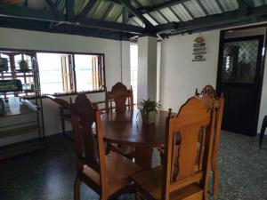 ein Esszimmer mit einem Holztisch und Stühlen in der Unterkunft Virginia Homestay 1North Siargao in Burgos + 12 Fotos