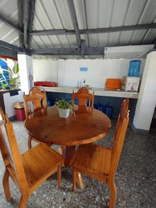 einen Holztisch und Stühle in der Küche in der Unterkunft Virginia Homestay 1North Siargao in Burgos