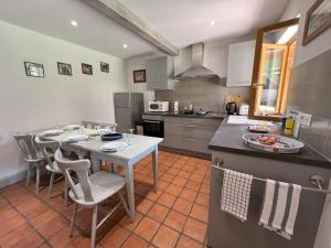 a kitchen with a table and chairs and a counter at Gîte chez Marie-Sarah petite maison calme parking in Ebersheim