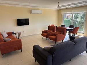 a waiting room with a couch and chairs and a table at Begon Villa in Alanya