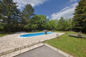a swimming pool in a yard with a stone walkway at Avalavanda Cherry Hill in Vlasi