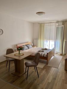 una camera da letto con un letto, un tavolo e delle sedie di Apartman San a Ruma