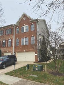 a brick house with a car parked in front of it at Maple Lawn Gem -sunny townhouse 3 bedrooms in Laurel