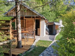 una cabina con terrazza in legno e tavolo di Glamping Narnia a Bovec Altre 16 foto