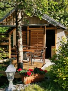 una cabina con tavolo e sedie su una terrazza di Glamping Narnia a Bovec