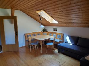 a living room with a table and a couch at Biohof Dimper - HühnerNest in Saulgrub