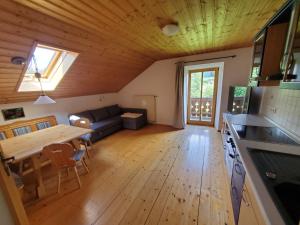 a kitchen and living room with a wooden ceiling at Biohof Dimper - HühnerNest in Saulgrub +18 photos