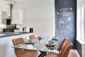 a dining room with a glass table and chairs at Cosy 3 bedroom house with Free parking and WiFi in Colchester +22 photos
