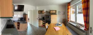 a kitchen with a wooden table in a kitchen at Ferienwohnung am Eschenberg in Vinstedt