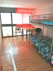 a room with bunk beds and a table and a desk at Roses in Roses