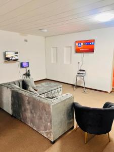 a large room with a projection screen and two chairs at Linies guest house in Benoni
