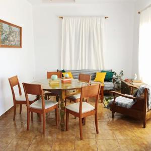 een eetkamer met een tafel, stoelen en een bank bij Villa Irene in Kalymnos