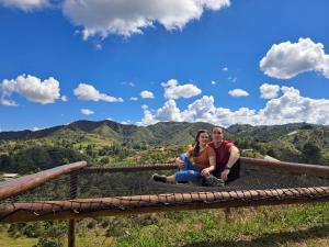 a man and a woman sitting on top of a mountain at Cabaña Celestial in Guarne