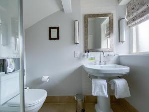 a white bathroom with a sink and a toilet at Victoria in Holkham