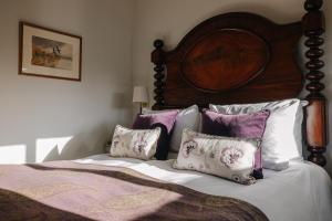 a bed with purple and white pillows on it at Victoria in Holkham