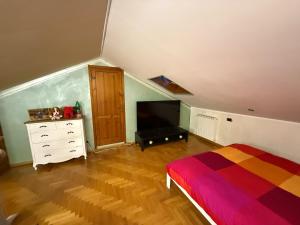 a bedroom with a bed and a dresser and a television at Anna's House in Arcidosso