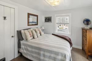 a bedroom with a bed and a window at Coastal Cottage Retreat Steps from the Beach cottage in Wareham