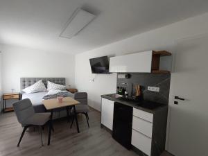 a room with a bed and a table and a kitchen at Ferienwohnung Gurabic in Maurach
