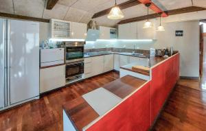 a large kitchen with white appliances and wood floors at Stunning Apartment In Åsljunga in Åsljunga +11 photos