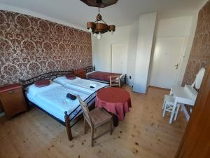 a bedroom with a bed and a table and chairs at Ubytování pod Věží in Teplice nad Metují
