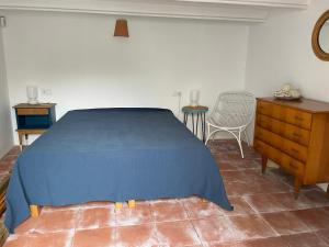 a bedroom with a blue bed and a wooden dresser at Maison de village avec piscine à 10 min de la plage Costa Brava in Sant Feliu de Guixols