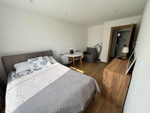 a bedroom with a bed and a table and a chair at Rūtas in Bērzgale in Bērzgale