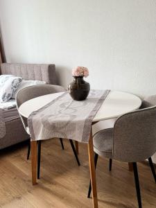 a table and chairs with a vase on top of it at Rūtas in Bērzgale in Bērzgale +8 photos
