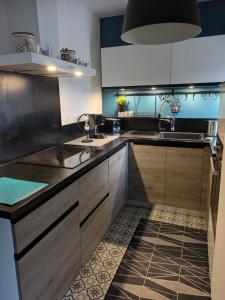 MeymacにあるLa petite Ganetteの木製のキャビネットとシンクを備えたキッチン