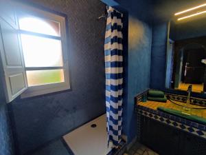 Chambre 4, Riad 3 Couple only au village naturiste في كاب داغد: حمام أزرق مع حوض ونافذة